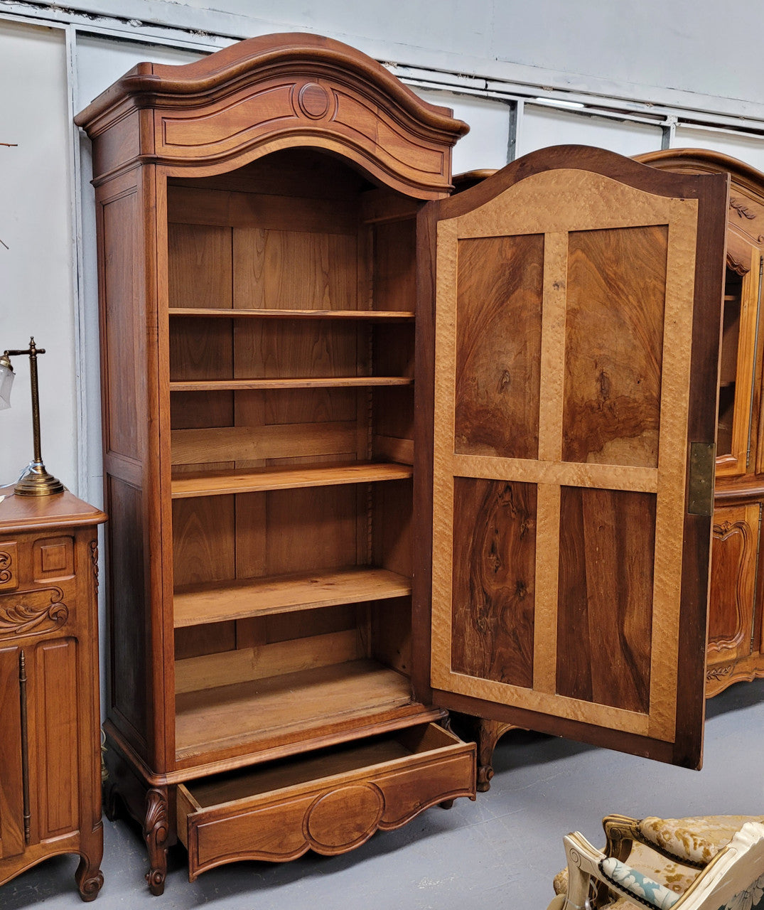 French Louis XV style Walnut armoire with single bevelled mirrored door. It has four adjustable shelves and a hidden exterior drawer at the bottom. It has been sourced from France and is in good original detailed condition.