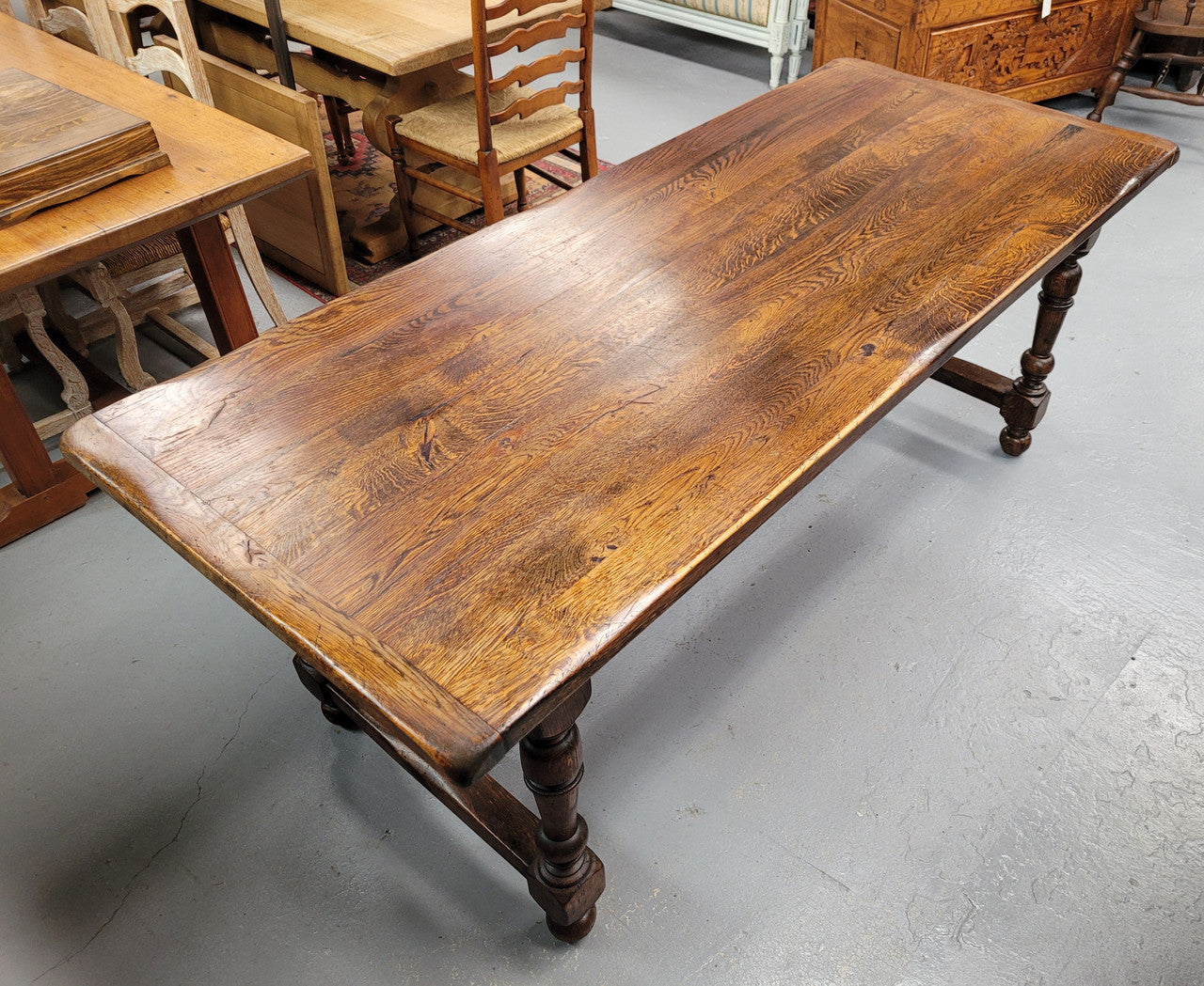 Rustic French Oak stretcher based farmhouse dining table that comfortably seats 6-8 people. It has been sourced from France and is in good original condition.