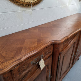 Parquetry top French oak Louis XV style sideboard with two draws and four cupboards. In good original detailed condition.