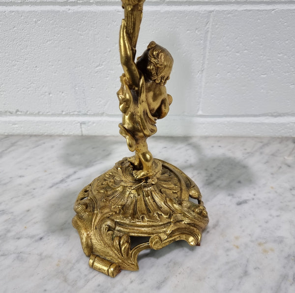 A pretty 19th Century French gilt bronze candelabra featuring a cherub. In good condition. Circa 1880.