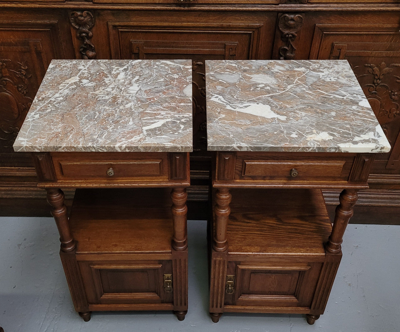Pair of French Antique Oak marble top bedsides Henry II style. They have a drawer, cupboard and an open shelf for all your storage needs. They have been sourced from France and are in good original detailed condition.