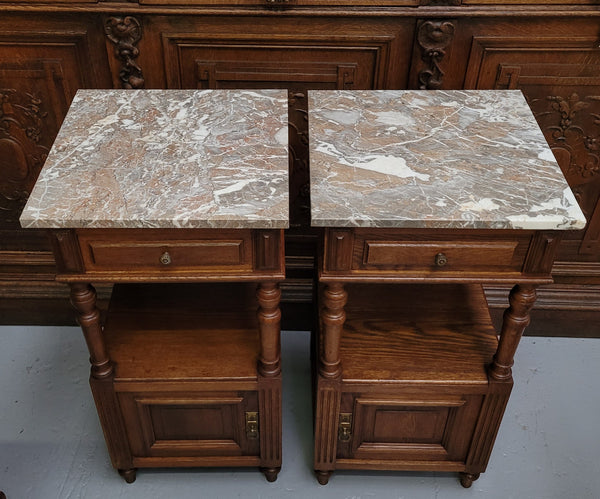 Pair of French Antique Oak marble top bedsides Henry II style. They have a drawer, cupboard and an open shelf for all your storage needs. They have been sourced from France and are in good original detailed condition.