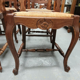 Set of six Louis XV style French Oak rush seat dining chairs. These chairs are very sturdy and have been professionally re-glued to ensure long lasting strength and sturdiness. They are in very good original detailed condition.