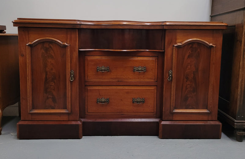 An English Victorian Mahogany sideboard with nine drawers. This amazing piece has loads of storage with three central drawers in the middle and a further six drawers. It has three each side located behind two doors. It has been sourced from locally and in original detailed condition.