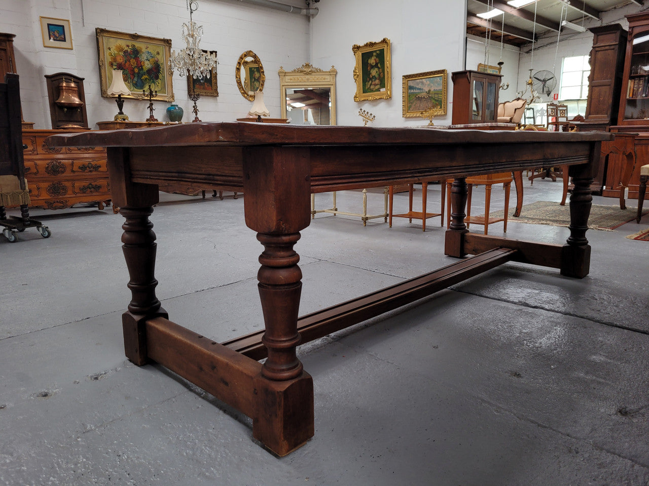 Charming solid rustic Oak stretcher base Farmhouse table. The table is circa 1950's and was custom made using reclaimed oak. It comfortable sits eight and could seat 10. It is in good original detailed condition.