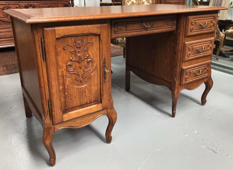 Beautifully carved French oak small desk with three drawers and a cupboard for all your storage needs. In good original condition. Great size for small spaces.