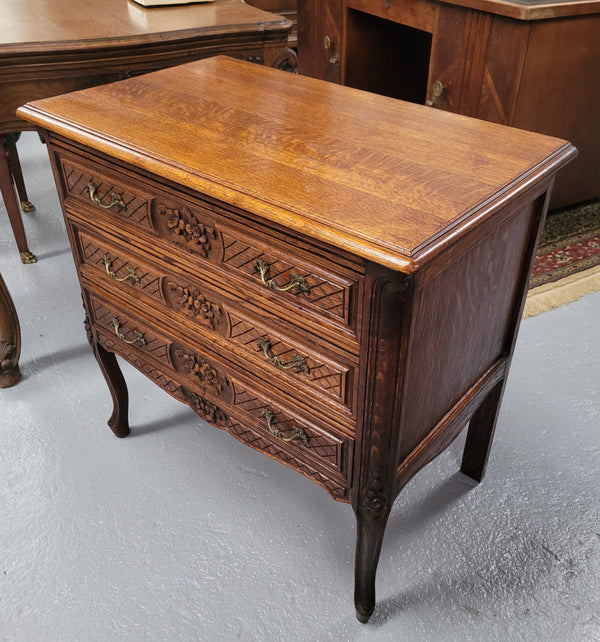 Rustic Louis XV style Oak petite three drawer chest featuring attractive carvings. It has been sourced locally and it is in good original detailed condition.