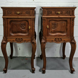 Beautiful pair of French Oak carved Louis XV style bedside cabinets with a white marble top, drawer and cupboard. They are in good original detailed condition.