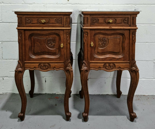 Beautiful pair of French Oak carved Louis XV style bedside cabinets with a white marble top, drawer and cupboard. They are in good original detailed condition.