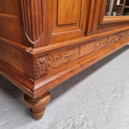 Imposing Louis XV style single mirrored door Walnut armoire. Features deep carved decoration, two interior drawers and three adjustable shelves. It is in good original detailed condition and has been sourced from France.