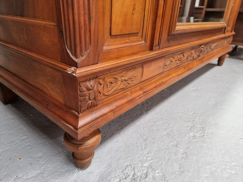 Imposing Louis XV style single mirrored door Walnut armoire. Features deep carved decoration, two interior drawers and three adjustable shelves. It is in good original detailed condition and has been sourced from France.