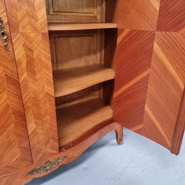 Charming French Louis XV Style Marquetry Inlaid Two Door Armoire. Features three adjustable shelves and ormolu trim. It has been sourced from France and is in good original condition.