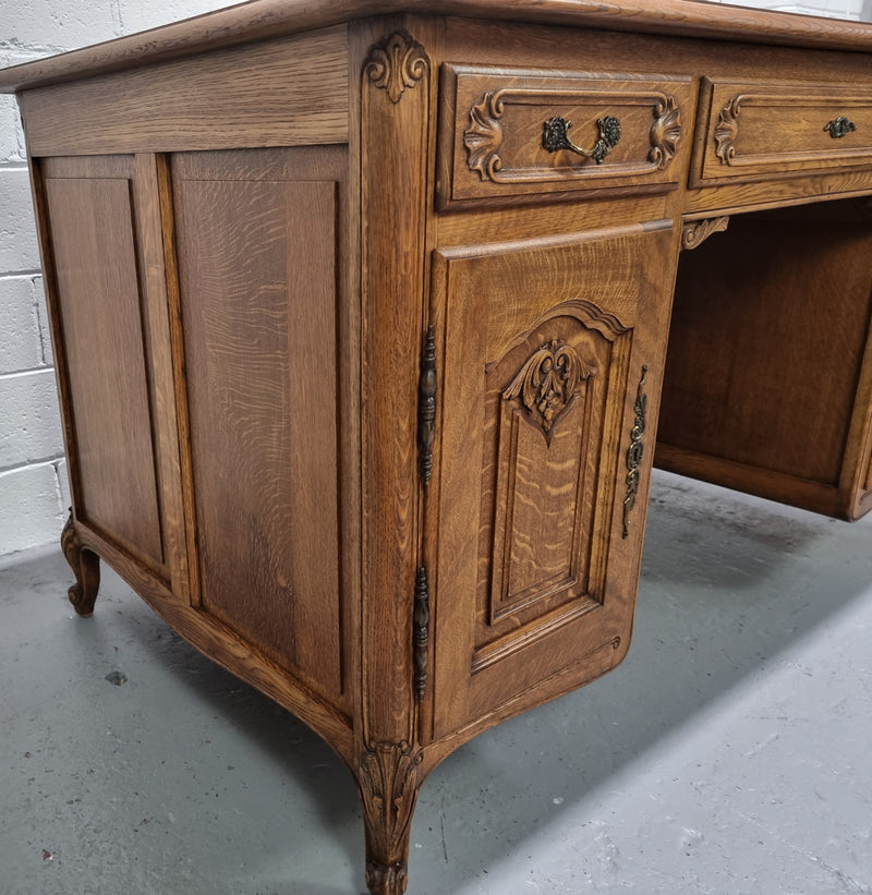 Fabulous French oak carved partners desk with a lovely parquetry top. It has three drawers and two cupboards on one side and two cupboards on the other side with no functioning drawers. It is in good original detailed condition.