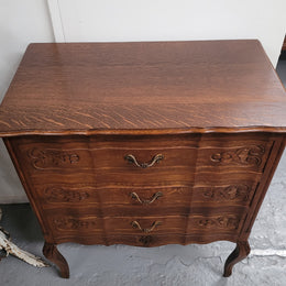 French Oak Louis XV style three drawer commode. It has been sourced from France and has decorative handles and carvings. It is in good original detailed condition.