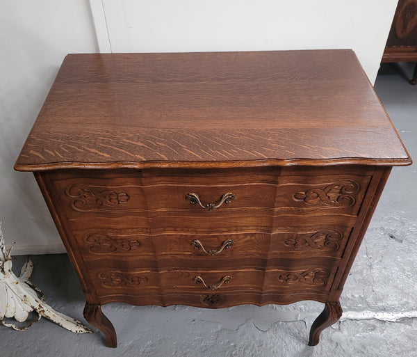 French Oak Louis XV style three drawer commode. It has been sourced from France and has decorative handles and carvings. It is in good original detailed condition.