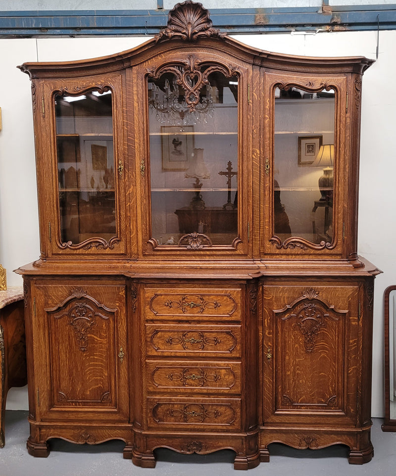 Impressive French Oak Louis 14th Style Display and Sideboard. It has 4 drawers, 2 bottom cupboards with 6 total shelves and 3 display doors with 3 shelves.  In good, detailed condition.