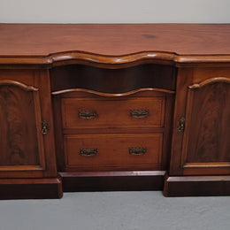 An English Victorian Mahogany sideboard with nine drawers. This amazing piece has loads of storage with three central drawers in the middle and a further six drawers. It has three each side located behind two doors. It has been sourced from locally and in original detailed condition.