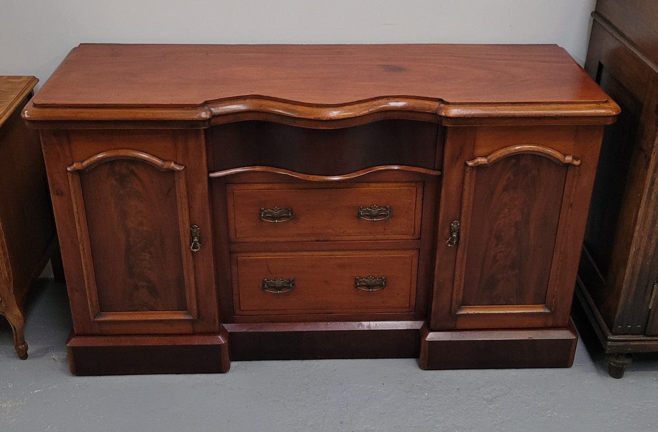 An English Victorian Mahogany sideboard with nine drawers. This amazing piece has loads of storage with three central drawers in the middle and a further six drawers. It has three each side located behind two doors. It has been sourced from locally and in original detailed condition.