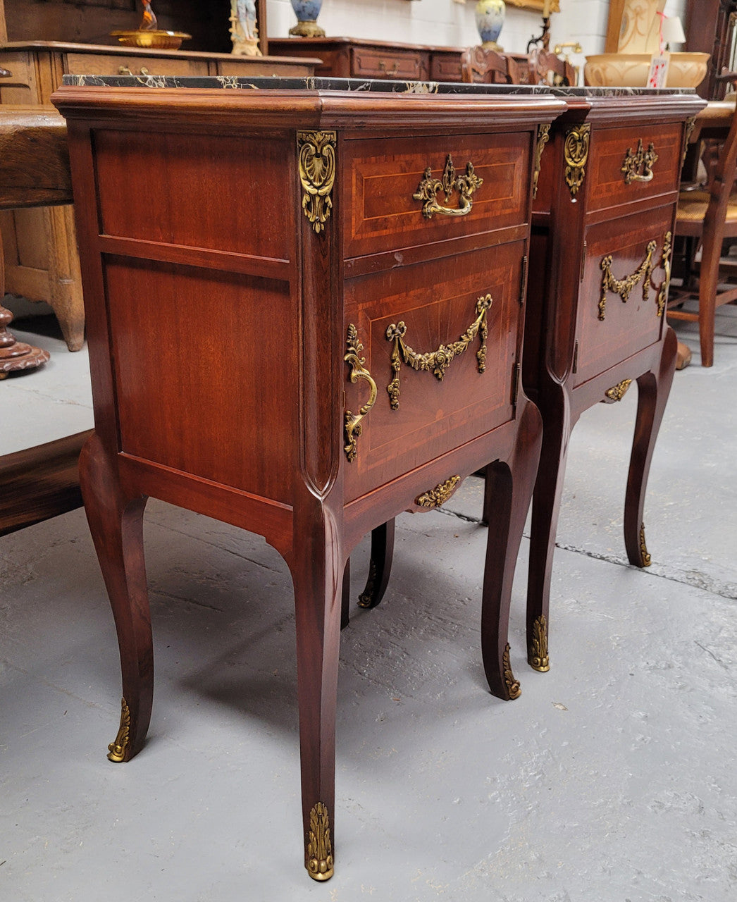 Appealing Louis XV style high quality bedside cabinets with black Portoro marble top and bronze mounts. They have been sourced from France and are in good original condition.