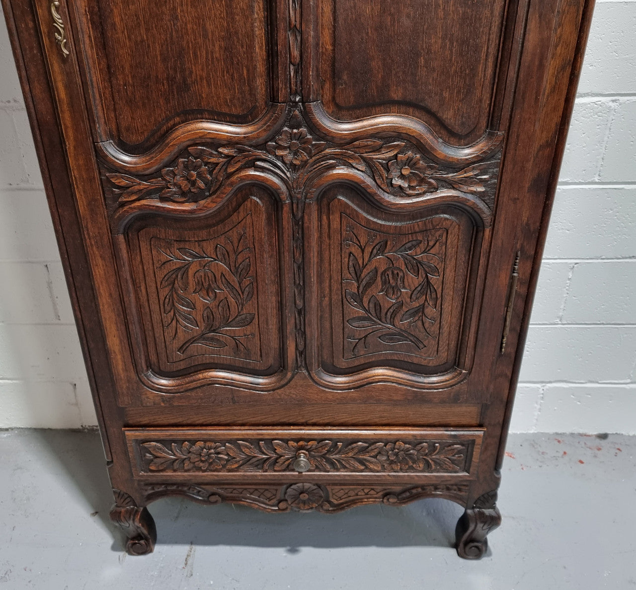 An Attractive French Louis XV style single-door ‘Marriage Armoire’. Beautifully arched crest with detailed carved flowers along with an arched single door which repeats the floral carvings. It is also has plenty of storage space with three adjustable shelves along with a drawer at the bottom. All in good original detailed condition.