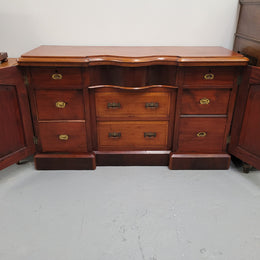 An English Victorian Mahogany sideboard with nine drawers. This amazing piece has loads of storage with three central drawers in the middle and a further six drawers. It has three each side located behind two doors. It has been sourced from locally and in original detailed condition.