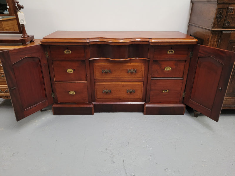 An English Victorian Mahogany sideboard with nine drawers. This amazing piece has loads of storage with three central drawers in the middle and a further six drawers. It has three each side located behind two doors. It has been sourced from locally and in original detailed condition.