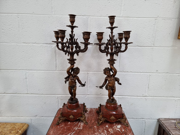 Pair of highly decorative French cherub candelabras with bronzed metal and marble. In good original detailed condition.
