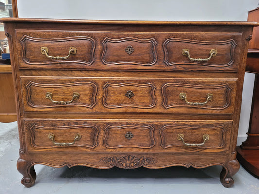 French Provincial Oak three drawer wooden top commode. It has elegant carvings and handles. It has been sourced from France and is in good original detailed condition.