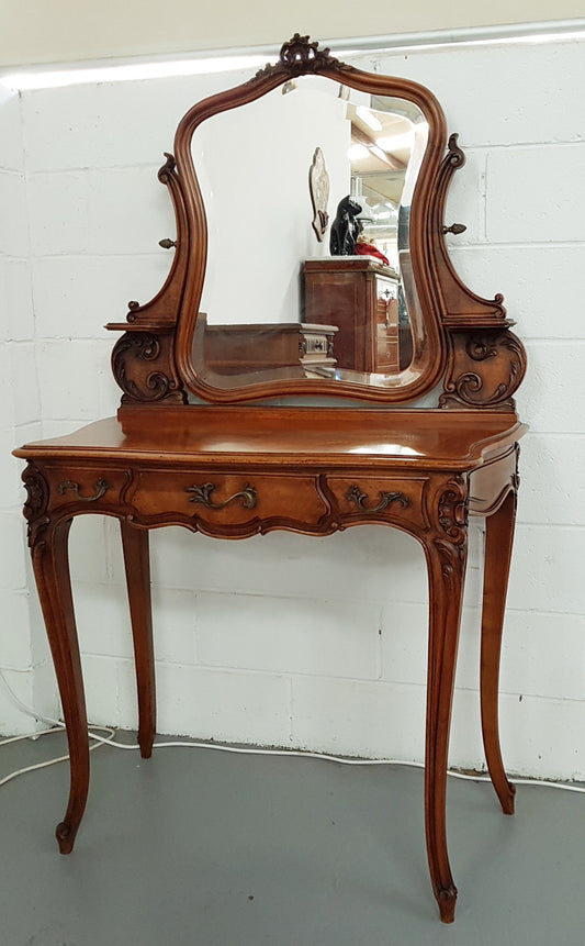 French walnut Antique Louis XV style dressing table of petite size, retaining it's original bevelled edge tilt mirror. In good original condition with three small drawers. Circa 1900.