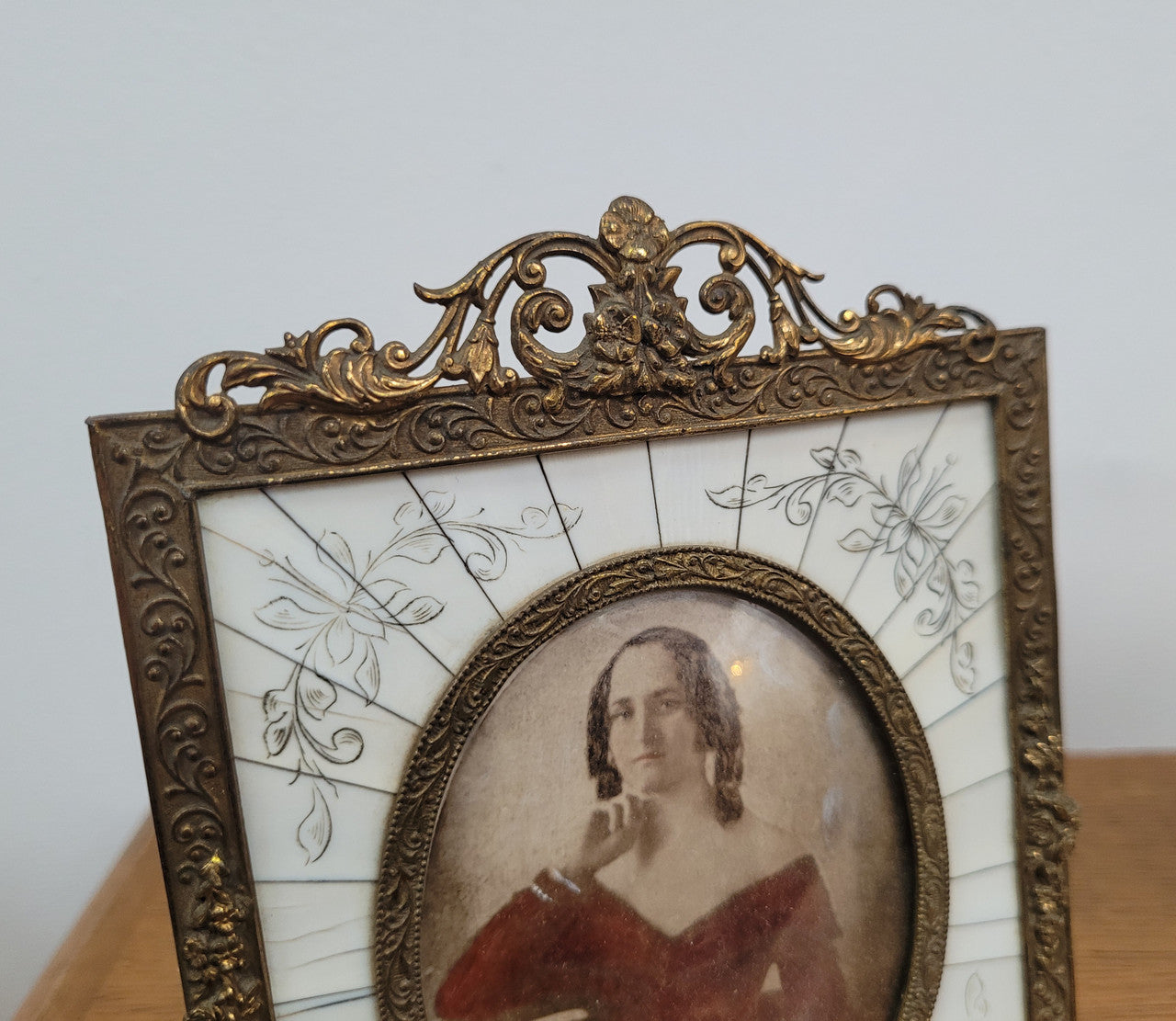 Hand coloured early photo of women in a stunning frame with paino key surround and detailed gilded metal frame.