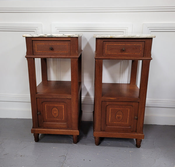 Pair of Antique French Oak Louis XVI style marble top bedside cabinets. They have decorative inlay and have been sourced from France. They are in good original detailed condition.