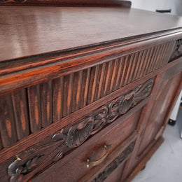 Art Deco Tudor style Oak sideboard with decorative carved detail. Plenty of storage space with two cupboards and four drawers. It has been sourced locally and is in good original detailed condition.