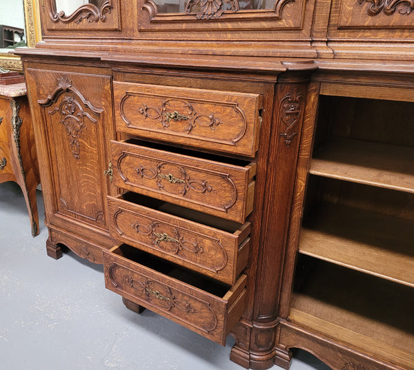 Impressive French Oak Louis 14th Style Display and Sideboard. It has 4 drawers, 2 bottom cupboards with 6 total shelves and 3 display doors with 3 shelves.  In good, detailed condition.
