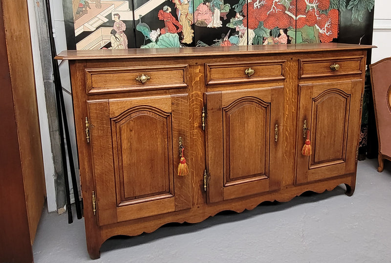 French Oak early 19th century three door buffet. It has a classic simple look and has three cupboards and three drawers. It is in good original detailed condition.