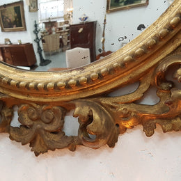 Large round carved wooden convex mirror. Still contains its original mirror which shows signs of aging.