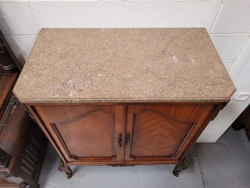 Stunning compact Louis 15th style two door walnut cabinet with ormolu trim and marble top. It is in good original condition.
