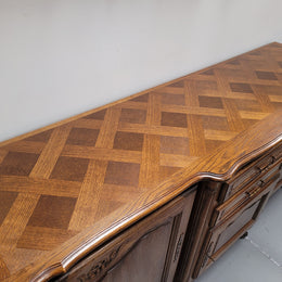 French Oak Louis XV style three door, two drawer, parquetry top sideboard. It has been sourced from France and is in good restored condition.