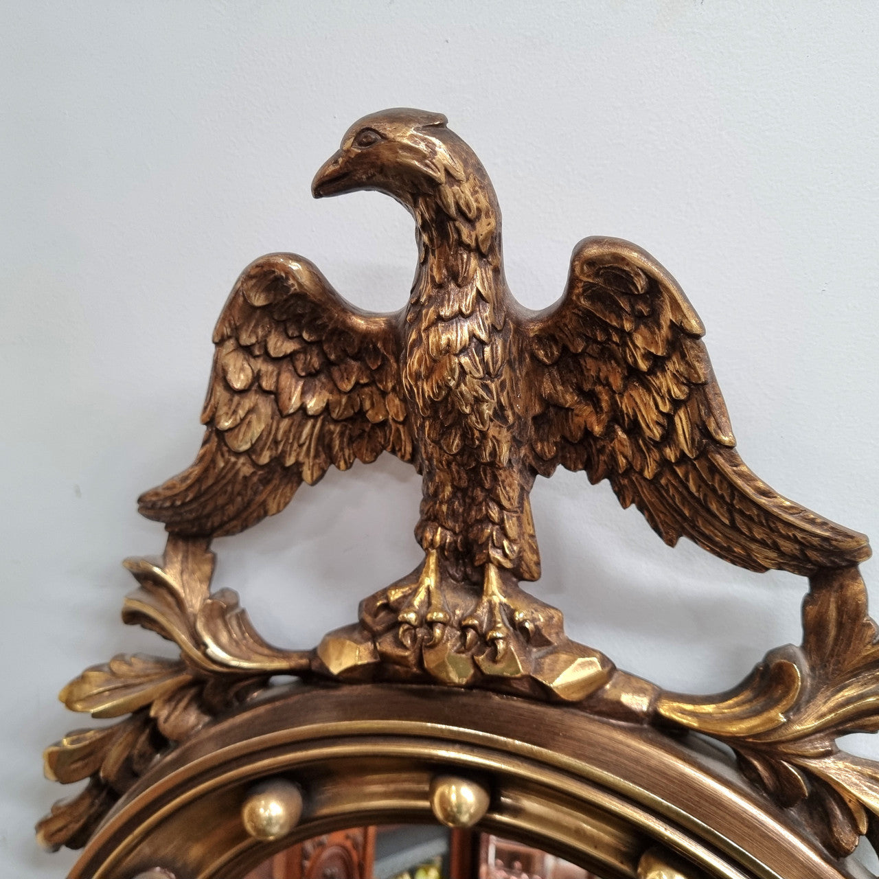 Vintage gilt framed convex mirror featuring carved eagle. It has been sourced from France and is in good original condition, please view photos as they help form part of the description.