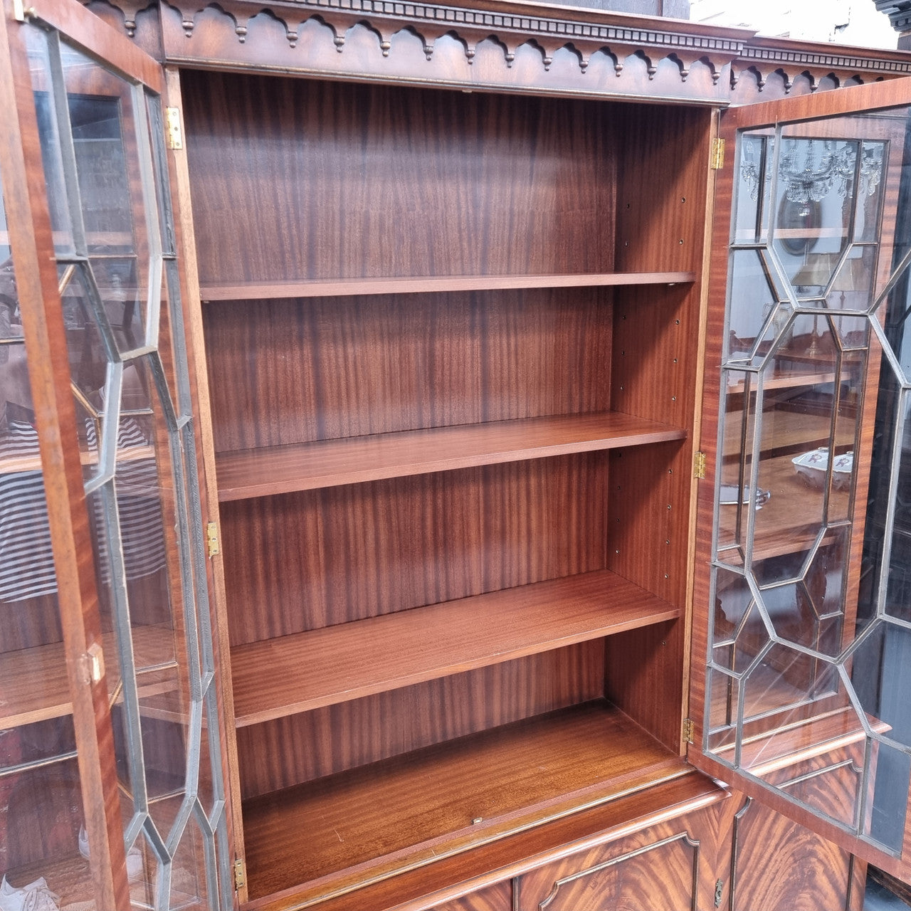 Georgian style Breakfront Flame Mahogany four door bookcase. A very impressive piece with plenty of storage and is of pleasing narrow proportions. It has been sourced locally and is in good original detailed condition.