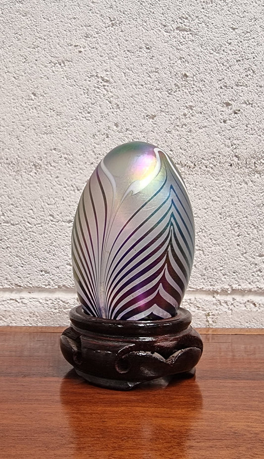 Iridescent glass egg shaped paper weight, on small wooden chinese stand. In good original condition. Please see photos as they form part of the description.