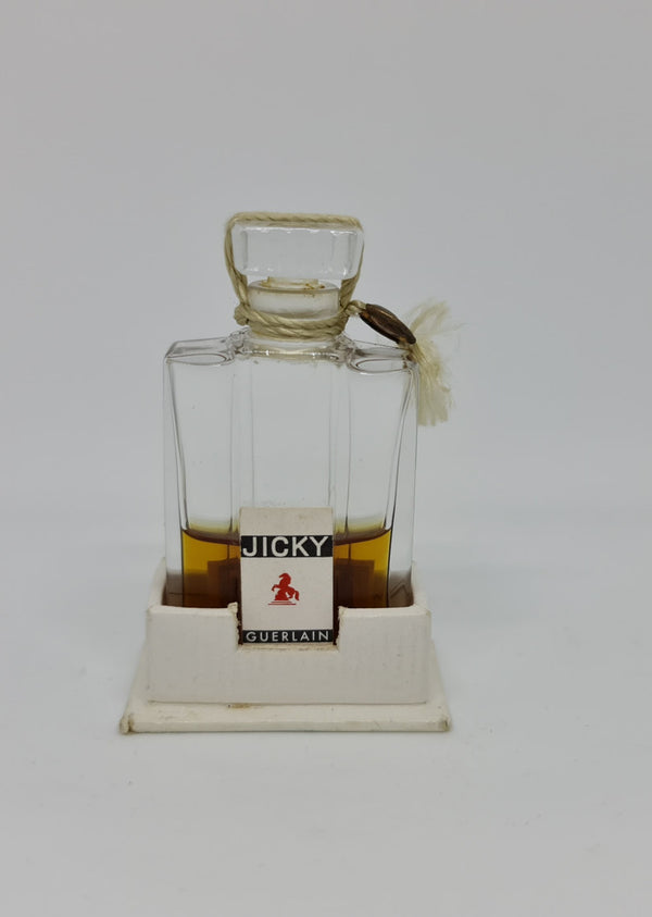 Vintage "Jicky" perfume bottle in great original condition with white base that it sits in.