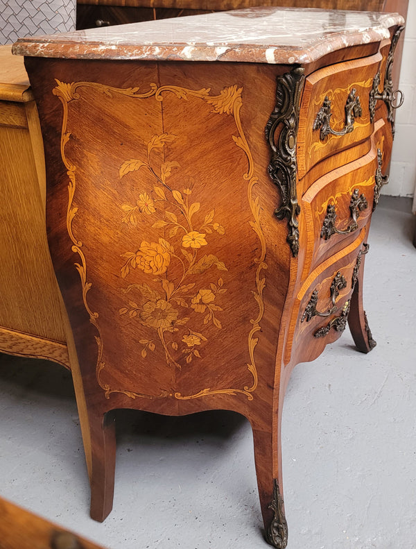 Antique French Louis XV style compact three drawer marble top commode with marquetry inlay and ormolu mounts. Sourced from France and in good original detailed condition.