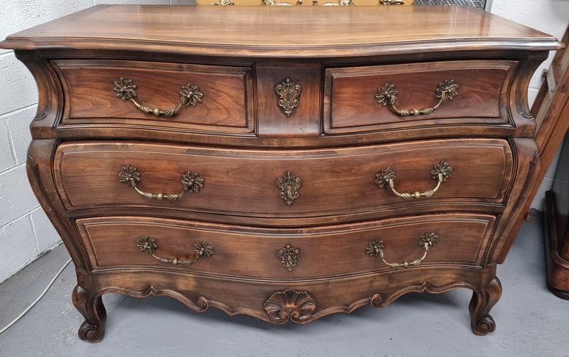 Impressive French Louis XV style Cherrywood four drawer commode, with a wooden top, two large drawers and two smaller drawers. Features attractive handles and a carved skirt and feet. In good original detailed condition.
