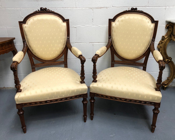 Beautiful pair of Vintage French Walnut Louis XVI style carved Fauteuils with lovely upholstery and wide seats . In good original detailed condition.