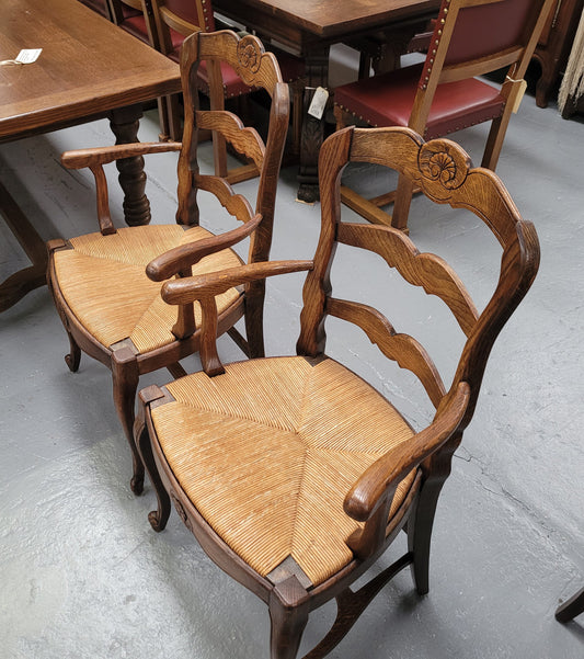 Pair of Louis XV Style Oak framed rush seated carver chairs. They have been sourced from France and in good original detailed condition.