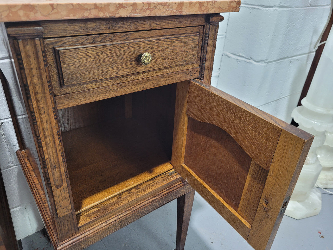 Beautiful pair of French oak bedside cabinets with marble tops. They have a drawer and cupboard for storage and are in good original detailed condition.