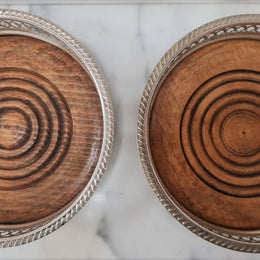 Gorgeous pair of vintage silver plate wine coasters with stunning turned wooden base. Not marked. In great original condition.