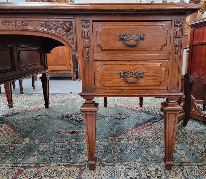 Substantial French Louis XVI style Oak partners desk. It has a beautiful leather top, two drawers on either side and decorative carvings throughout. Sourced from France and in good original detailed condition.