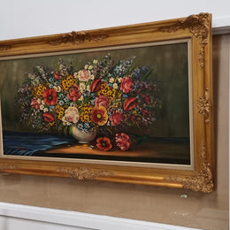 Sourced from France a stunning colorful floral oil painting on canvas. It is in a decorative gilt frame and is signed. It is in good original detailed condition.