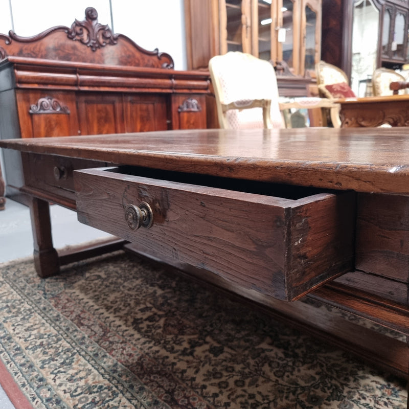 Impressive large size rustic French Oak coffee table with two drawers on a stretcher base. In good original detailed condition and sourced from France.